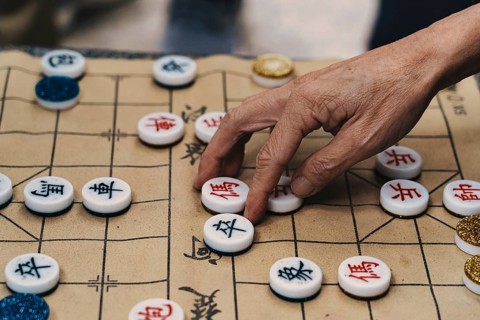 Cropped close-up of an unrecognizable elderly person's hand selectively placing tiles on the