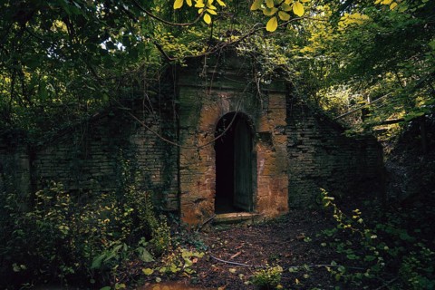 A mysterious overgrown stone entrance near Chateau Caumont in France Surrounded by dense greenery,