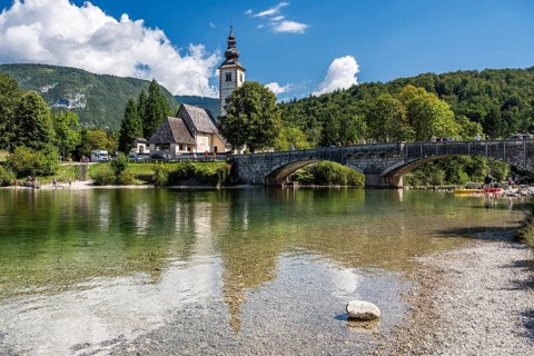 RIBCEV LAZ, SLOVENIA, AUGUST 26, 2025:A picturesque view of the historic stone bridge and the