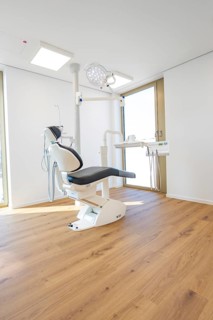Bright dental practice with a modern dental chair and wooden floor, dentist, medical center at the