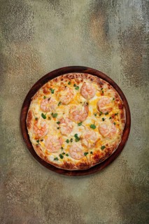 Four cheese pizza with shrimp and fresh microgreens, served on a wooden board, homemade, no people