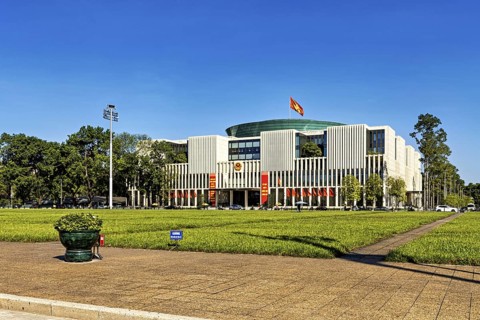 Modern building with glass fronts, flags and surrounding lawn under a clear sky, building of the