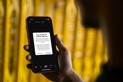 An iPhone screen with the TikTok homepage showing Sorry, TikTok isn't available right now