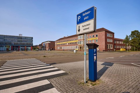 Signpost to car park, parking ticket machine, zebra crossing, brick architecture, tree, blue