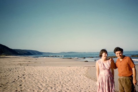 Man and woman standing on the sandy beach of Lorne, Victoria, Australia, 1956