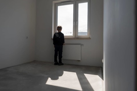 Happy young boy in his new empty room in the new flat in Wroclaw, Poland
