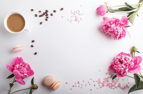 Pink peony flowers and a cup of coffee on a white background. Morninig, spring, fashion composition