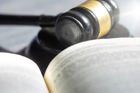 Symbolic picture court hearing: close-up of a judge's hammer and the civil code