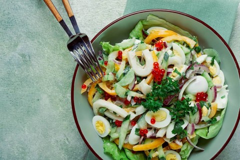 Salad with squid, fresh cucumber, eggs, sweet pepper, red onion, with dressing, homemade, no people