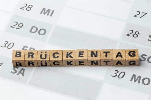 Bridge day symbol image: Letter cubes on a calendar show the word BRÜCKENTAG (bridge day)