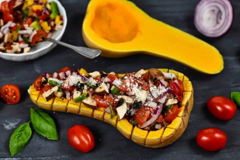 Vegan baked Butternut squash filled bell pepper, cherry tomatoes, red onion and mushrooms