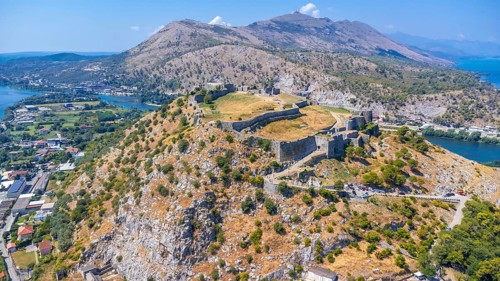 Aerial drone view of Rozafa Castle in the city Shkoder and its walls next to the lake and the river