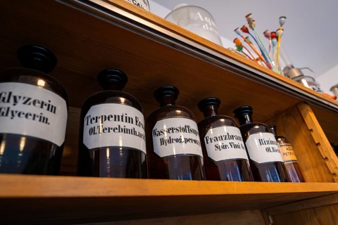 Shelf with labelled glass pharmacy bottles in an old pharmacy, Calw Tannery Museum, Black Forest,