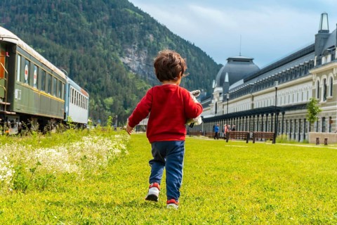Boy on his back running in the old train station of Canfranc in the Pyrenees. Spain