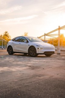 A white car in a city car park at sunrise, Tesla new Model Y Juniper, Nagold, Germany
