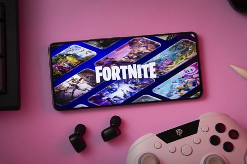 Dhaka, Bangladesh- 12 June 2025: Phone displaying Fortnite on pink surface with a gaming controller