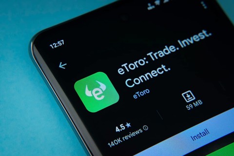 Dhaka, Bangladesh- 29 May 2025: On a blue surface, a smartphone displays the eToro app within the
