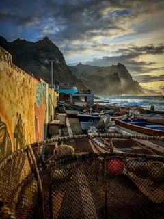 Harbour with fishing boats on painted wall, graffiti, mural, waves hitting the rocky coast in