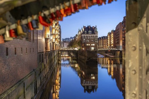 Water castle in Hamburg's Speicherstadt at blue hour with love locks in the foreground and