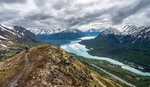 Climbers on a hiking trail on Slaughter Ridge, views of snowy mountains in spring and turquoise
