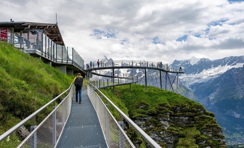 Tourists on the First Cliff Walk, metal trail on a rocky outcrop, Grindelwald First, in front of