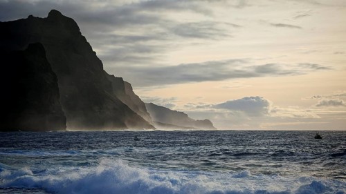 Stormy sea, dusk with silhouette of mountains in the background under a cloudy sky, Ponta do Sol,