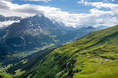 View of mountain landscape with green meadows and alpine huts Bachlager, Grindelwald First,