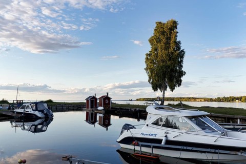 Motor boats, family boat in marina, guest harbor, characteristic Swedish marina in evening light,