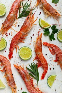 Langoustines, Australian, freshly frozen, top view, on a light background, lime and greens