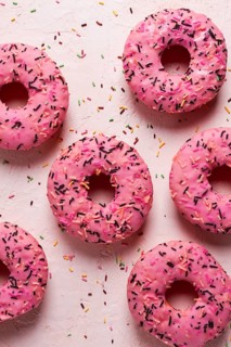 Donut with strawberries, in pink glaze, confectionery decoration, top view