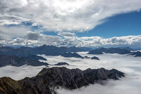 View from the Nebelhorn summit to mountains of the Allgäu Alps, mountains rising from fog in the