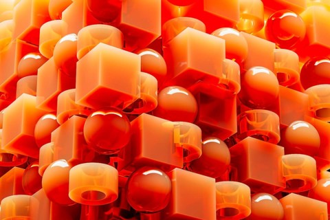 An engaging array of 3D geometric shapes in fiery orange tones combines spheres and cubes, creating
