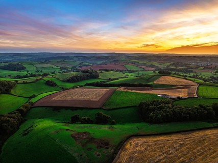 Sunset of Devon Farms and Fields over Berry Pomeroy from a drone, Totnes, England, United Kingdom