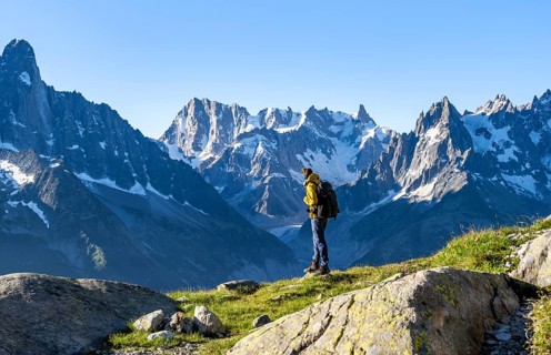 Young man in front of impressive mountain landscape in morning light, picturesque mountain