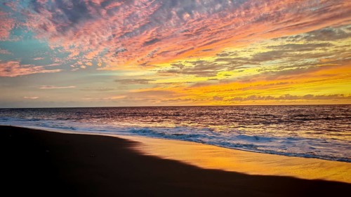 Play of colors in the sky during sunset at the sea with soft waves, romantic, Tarrafal de Monte