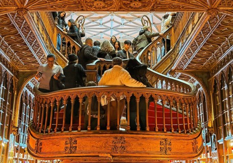 Livraria Lello, interior view of the Lello bookstore with lots of tourists on the curved wooden