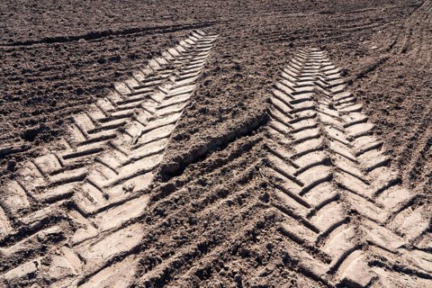 Tractor tracks, agricultural trails at a cultivated field in springtime, farmland near Wesertal,