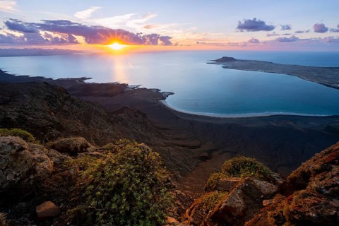 View from steep cliffs to sea and coast with sun stars, Mirador del Porrito viewpoint at sunset,
