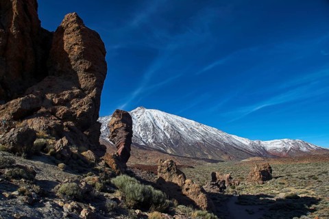 Roques de Garcia, rugged rocks against a snow-covered mountain under a clear blue sky, Teide,