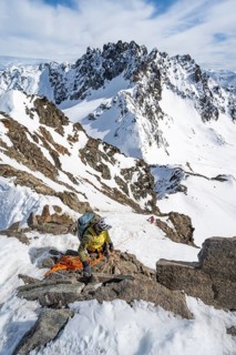 Mountaineer belaying on a steep snow slope, belaying on a rope, ascent to the summit of Piz