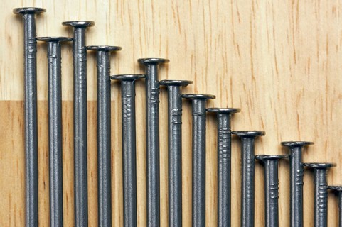 Declining Graph of Nails on a Wood Background