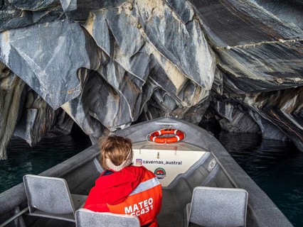 Woman sitting at the front of a tour boat, excursion boat inside the marble caves, Puerto Sanchez,
