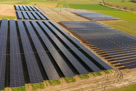 Rows of solar panels on fields seen from above symbolize renewable energy, Agri PV Bau für