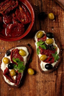 Sandwich with cream cheese, dried tomatoes, olives, breakfast, top view