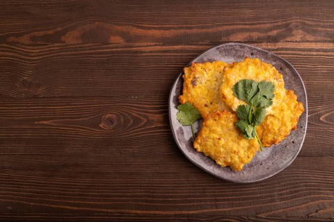 Fried crispy Chicken pancakes on brown wooden background. top view, flat lay, copy space