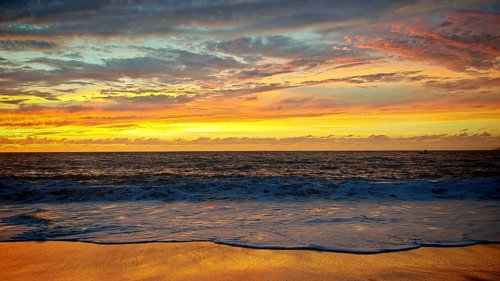 Romantic, golden, colorful sunset over the sea with soft waves and golden horizon, Tarrafal de