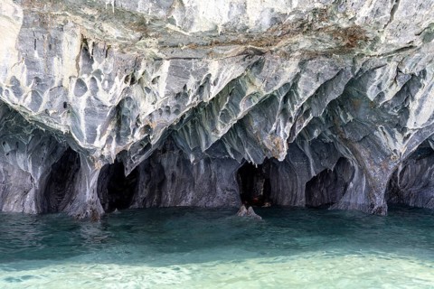 Marble caves (Cuevas de Mármol) with eroded rock formations over turquoise-coloured water, Lago
