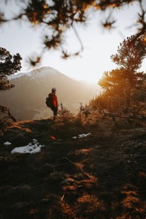 Hiker in the Allgäu at sunset in spring on the Zirmgrat near Pronten in the Allgäu