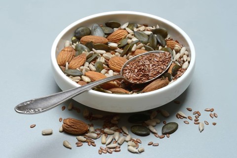 Seeds in bowls, mix of almond seeds, sunflower seeds, linseeds and pumpkin seeds