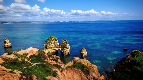 Wide views of and rock formations and rock arches in the azure blue sea, Praia do Camilo, Lagos,